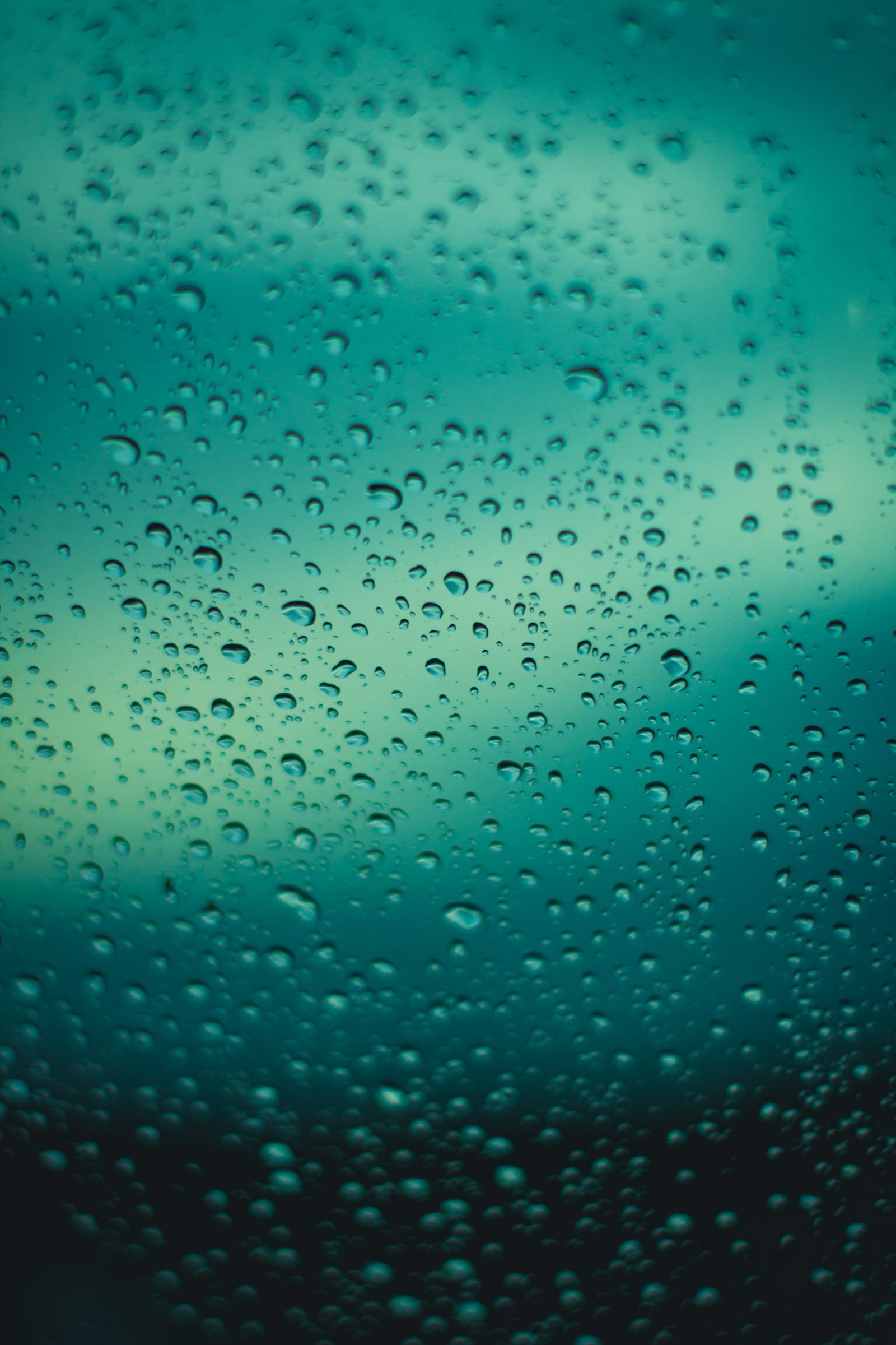Close-up view of water droplets on a window during a rainy day, creating a calming and reflective atmosphere.