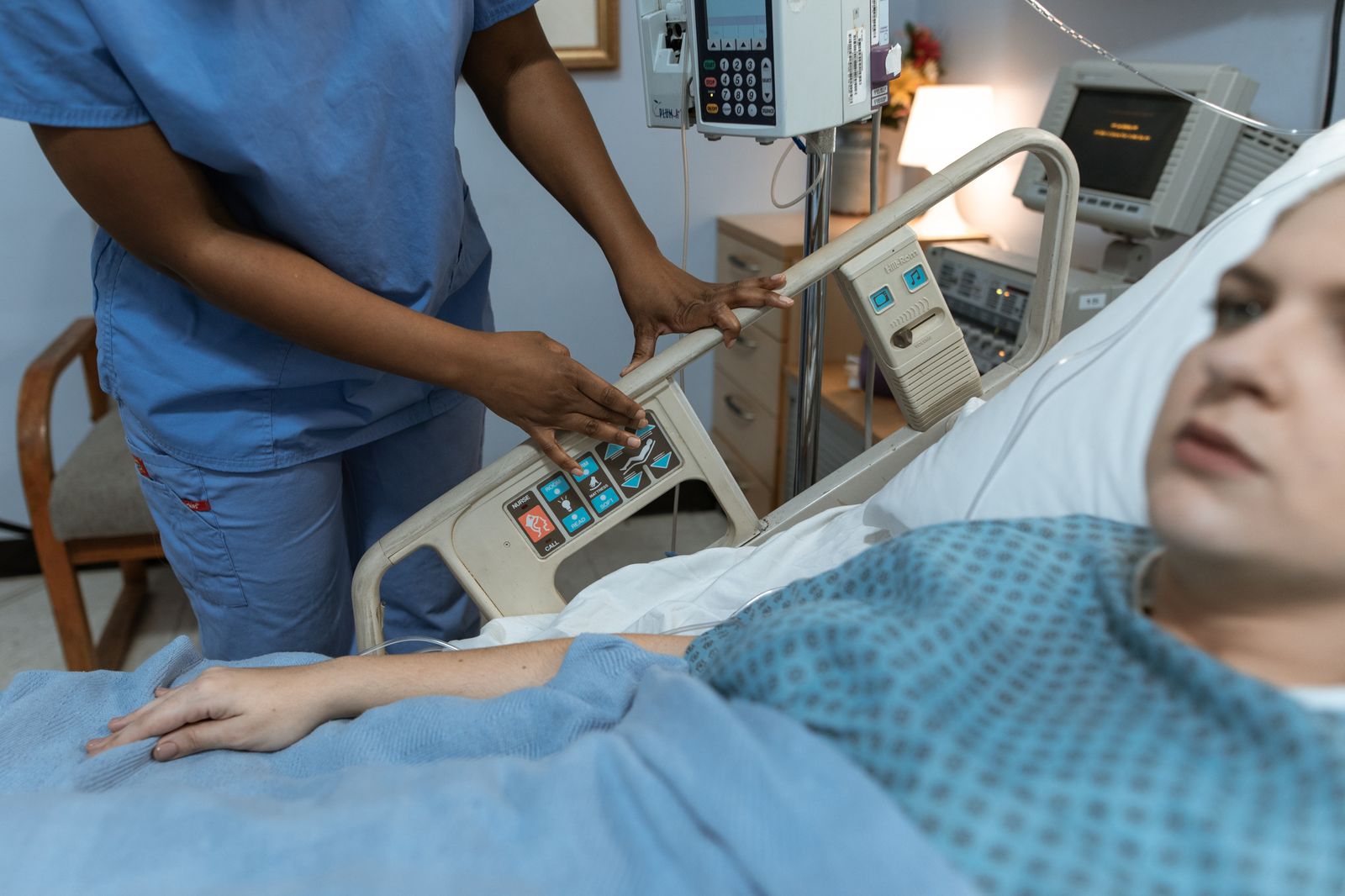 Free Nurse providing care to a patient in a hospital room with medical equipment. Stock Photo.