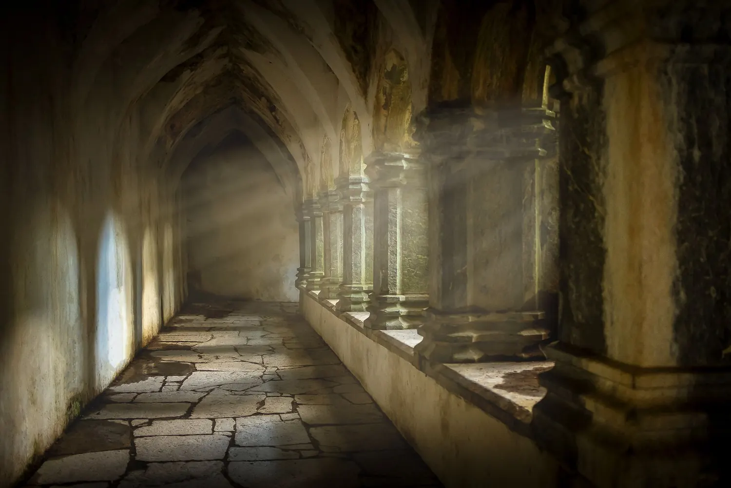 Rayons de lumière traversant les arcades d'un cloître médiéval