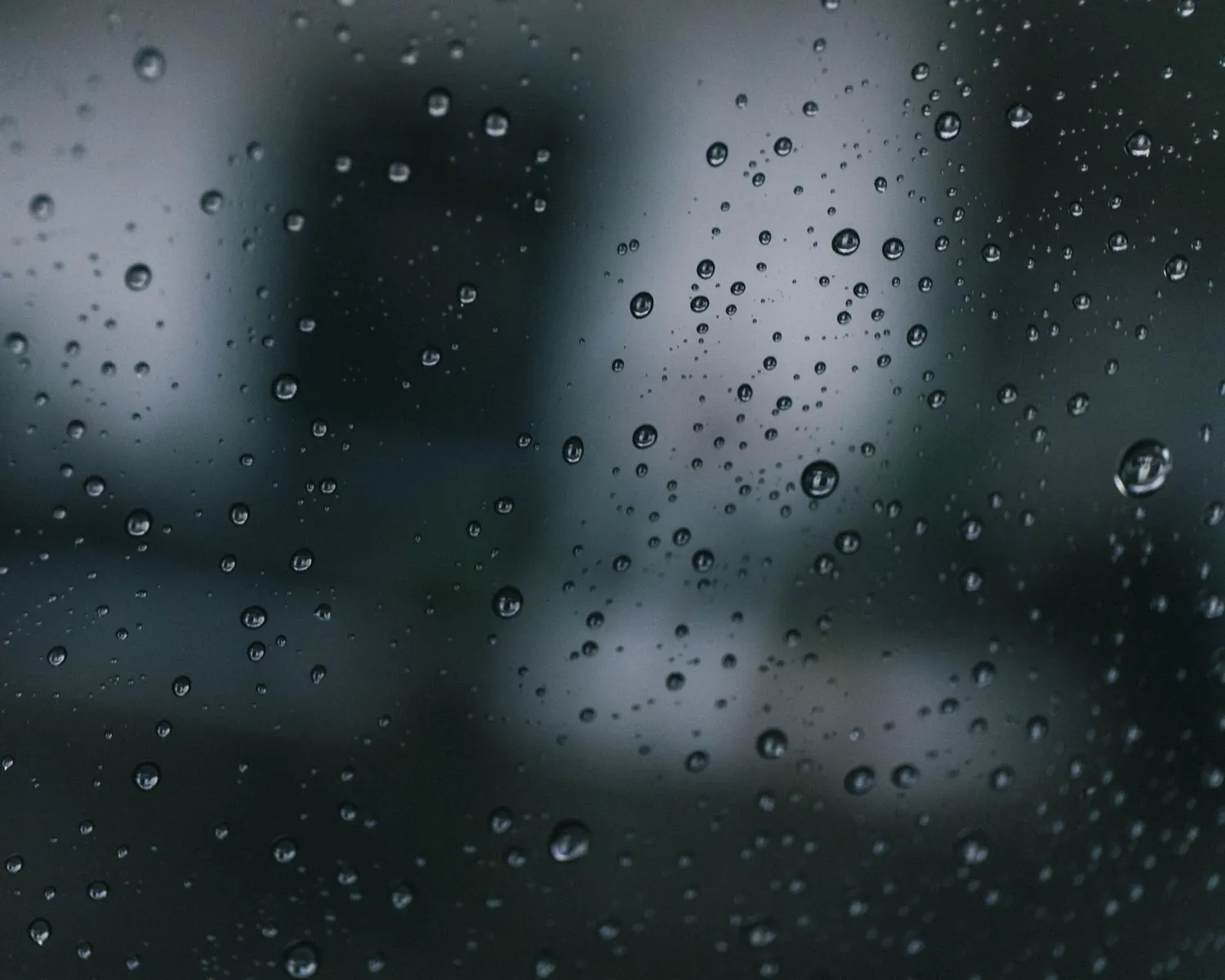 Gouttes de pluie sur une vitre, arrière-plan flou